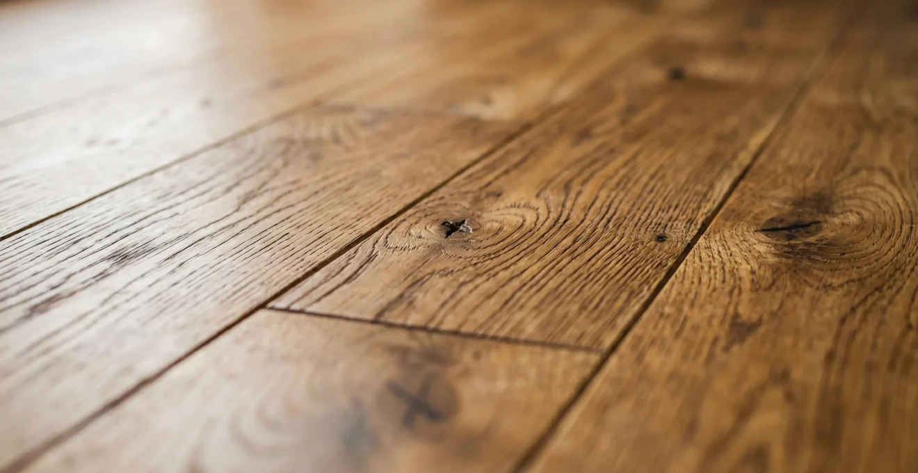 Inspection détaillée d'un parquet en chêne massif avec focus sur l'authenticité des matériaux durables en Suisse